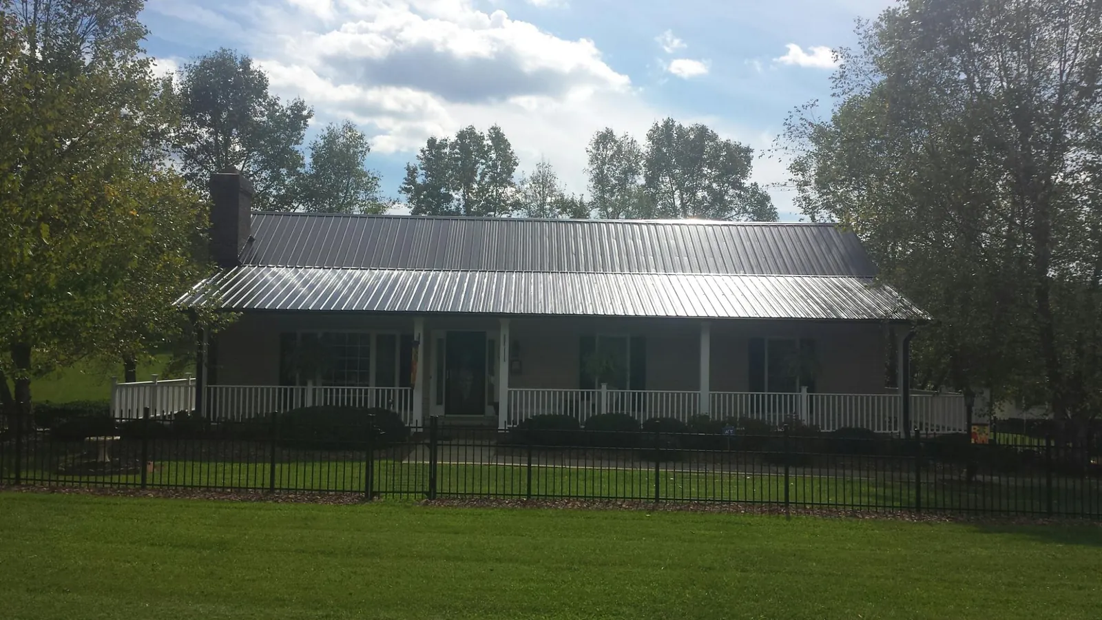 Gray metal roof on a brick ranch with a full width front porch — Gutter Guard Installation work by our crew in Warrenton